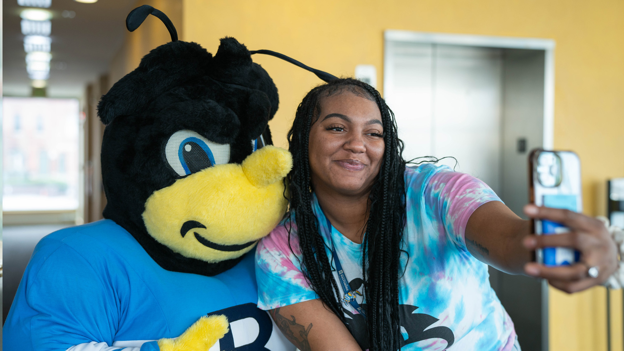 A student takes a selfie with Eubie the mascot