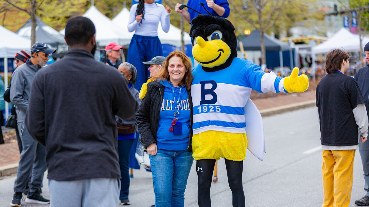 A person and bee mascot pose for a photo