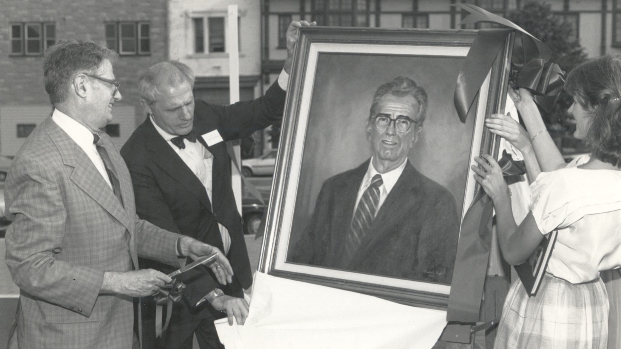 Yale Gordon's portrait is revealed to him while others look on.